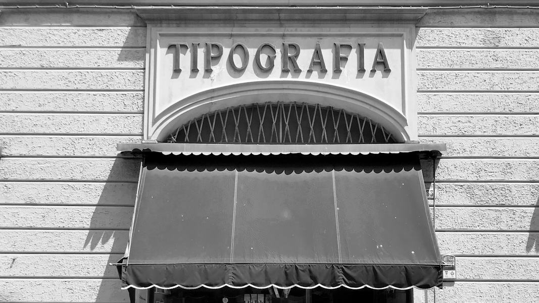 Fachada con el rótulo «Tipografia» sobre un toldo.